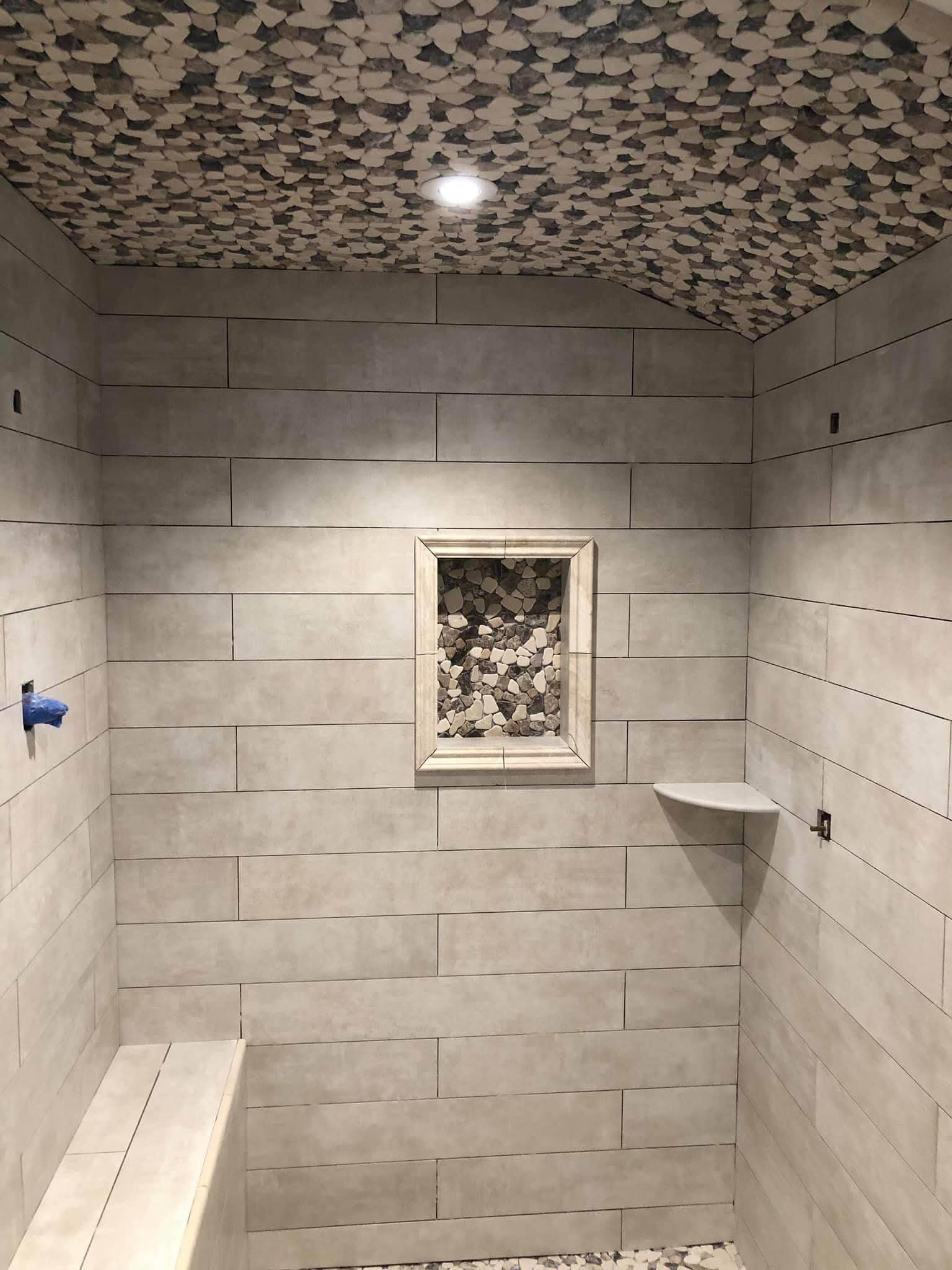 Área de duche com revestimento bege e teto com mosaico decorativo