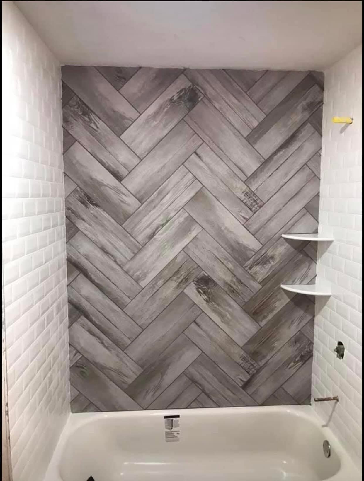 Banheira com parede em padrão espinha e nichos laterais