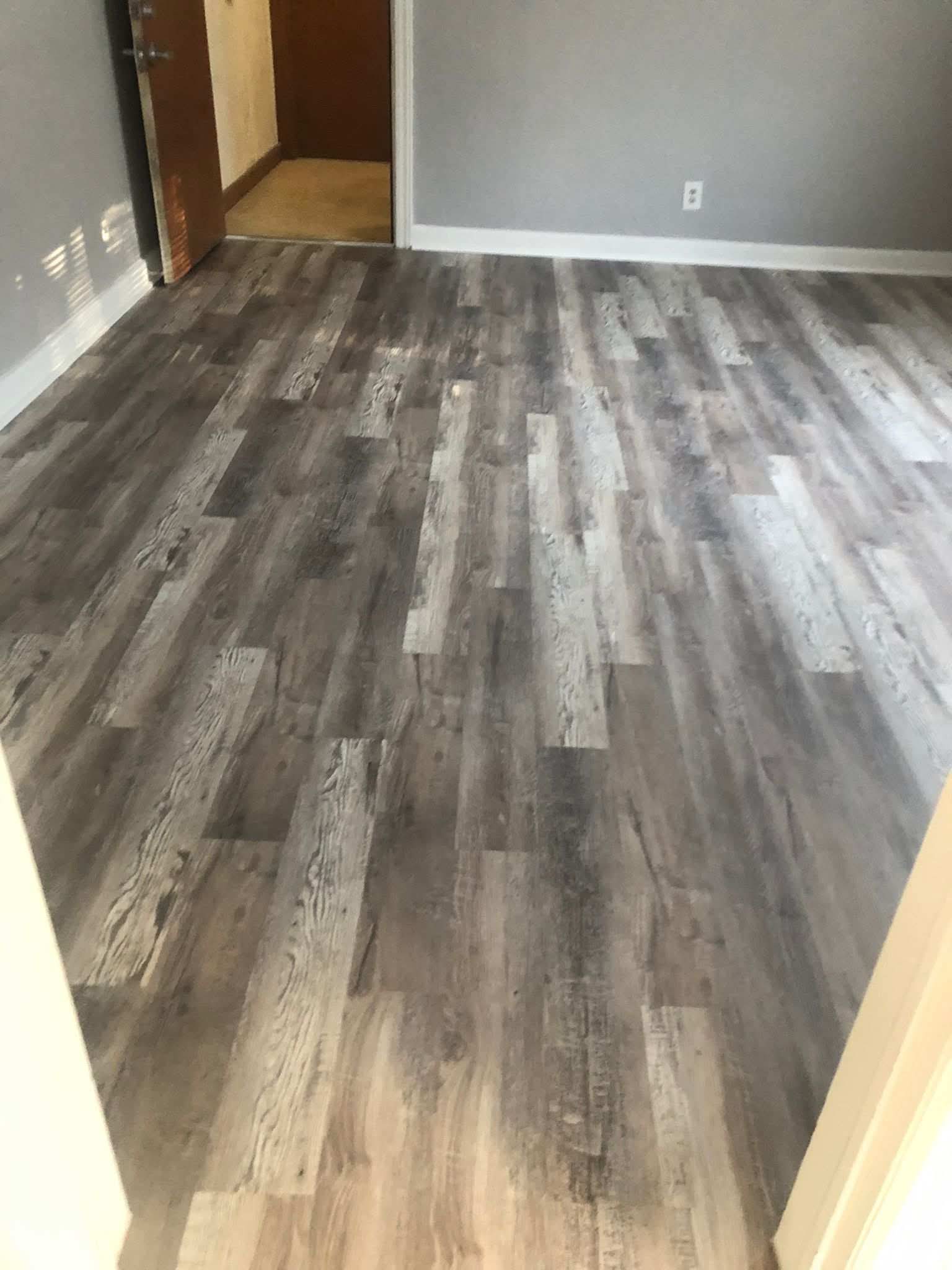 Instalação de piso em madeira cinza num quarto